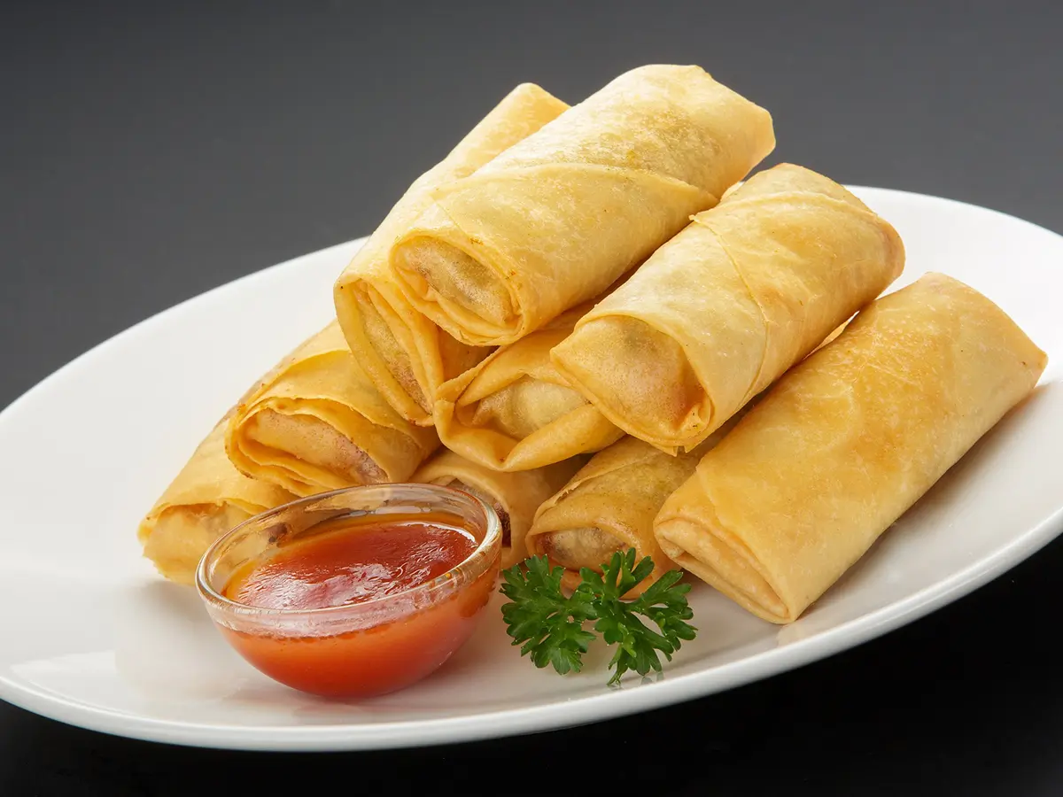 Crispy fried egg rolls filled with savory vegetables and meat, served with sweet and sour sauce at Jade Garden，a Chinese Restaurant in Creston